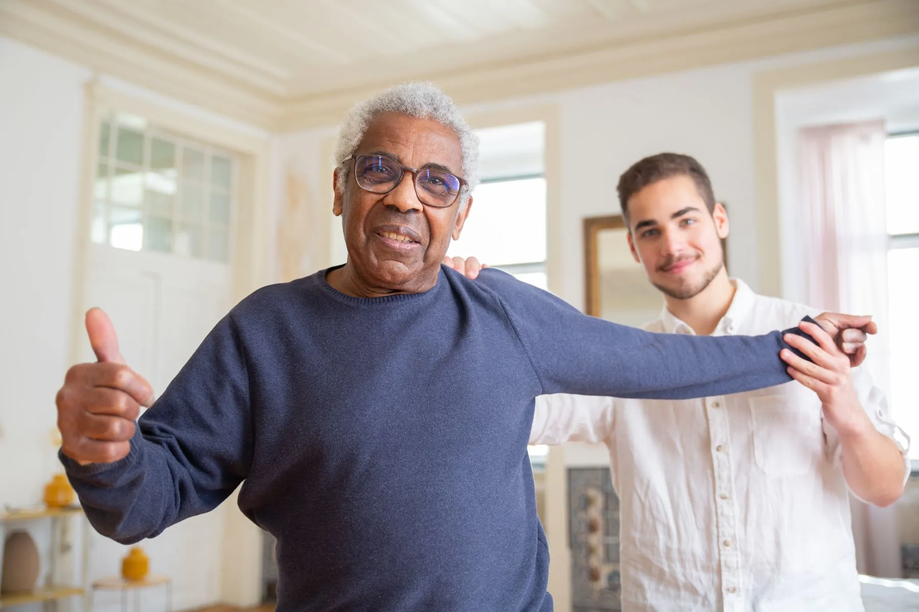 An older man enjoying gentle activity with a care worker