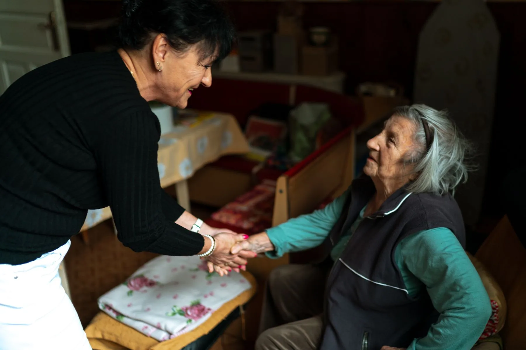 An older person welcoming a care worker at home