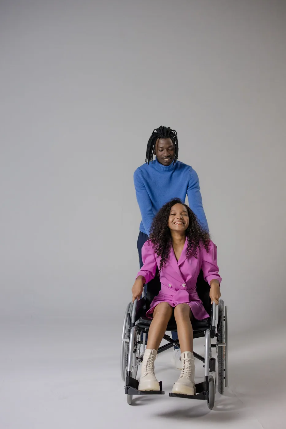 A smiling wheelchair user spending time with a companion