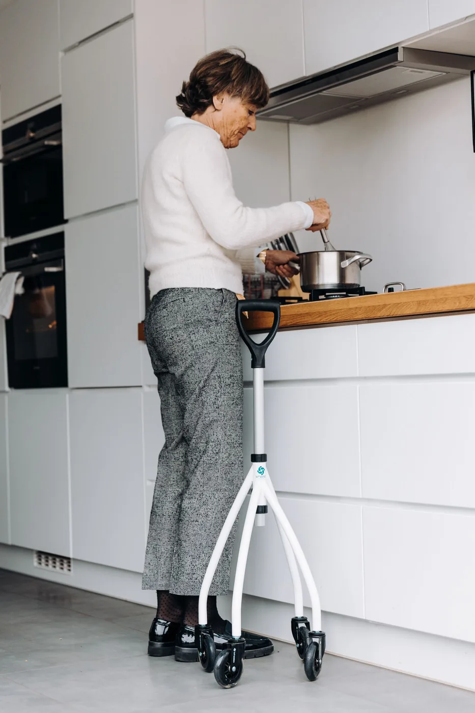 An older woman independently preparing food in an accessible kitchen